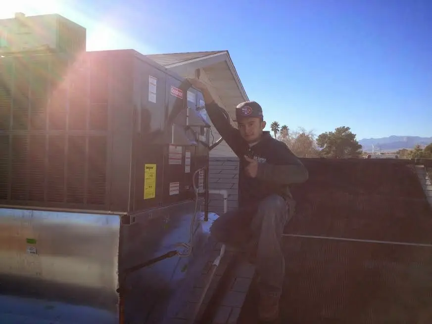 HVAC technician performing AC Tune-Up on a rooftop unit in La Presa