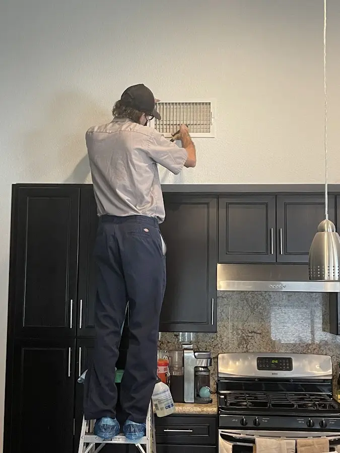 Technician inspecting an air vent during HVAC service in La Presa